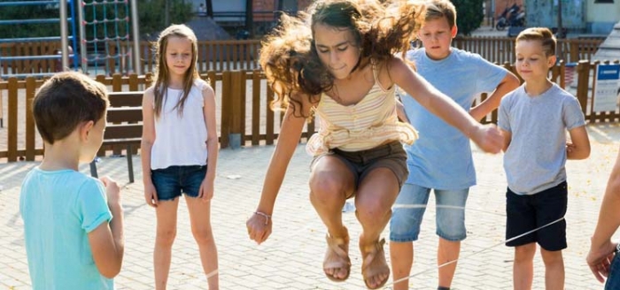 Kinder beim Seilspringen und Leben in der Stadt