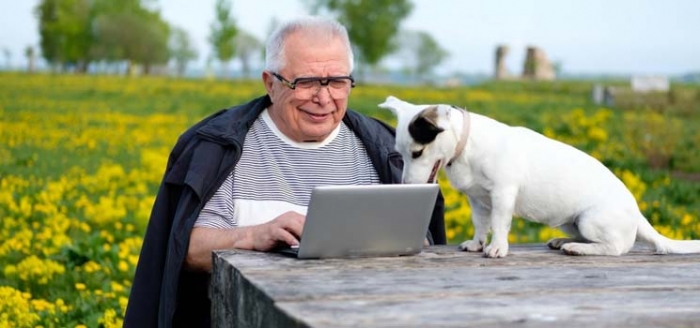 Alter Mann vor dem Laptop hat Ziele erreicht