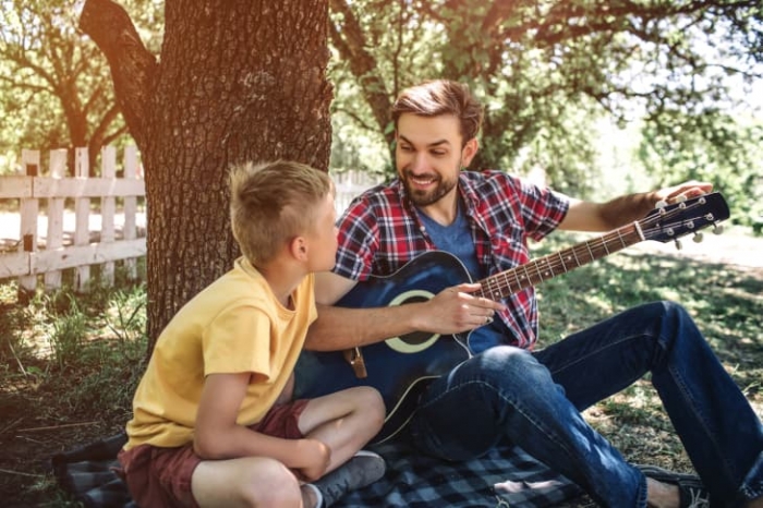 Vater und Sohn spielen Gitarre