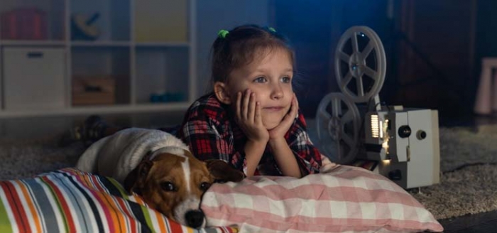 Kind auf dem Bett schaut sich einen Film an Kind auf dem Bett schaut sich einen Film an