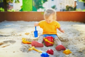 Kind spielt im Sandkasten Kind spielt im Sandkasten